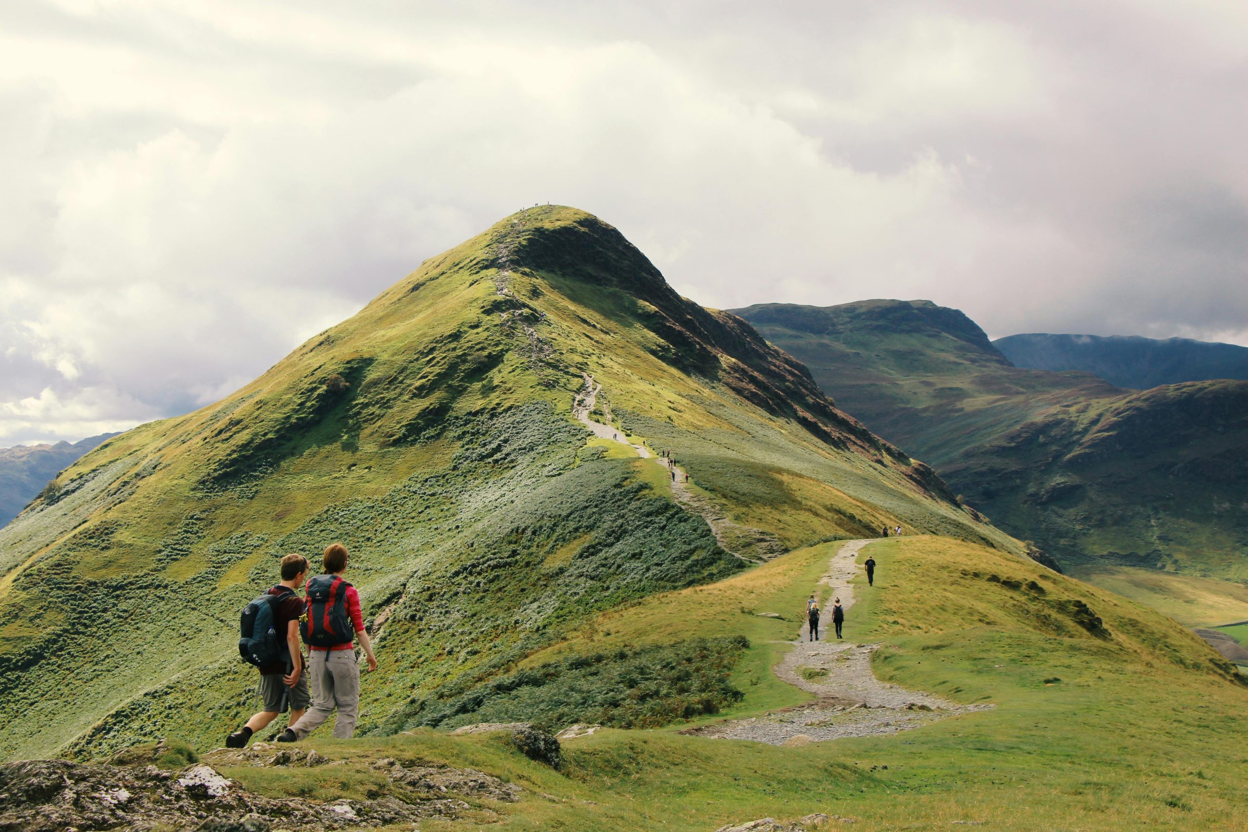 Hikers enjoy a scenic walk along a ridge in the stunning Lake District, England.